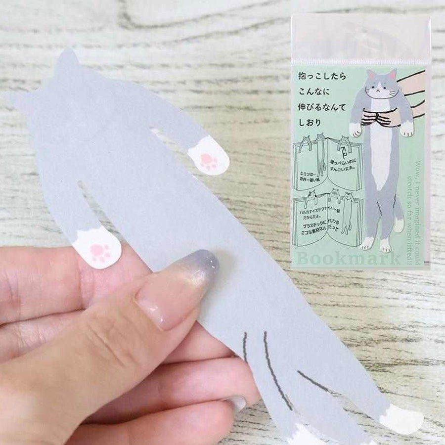 Hand holding the Kutsushita hugging cat bookmark with its packaging