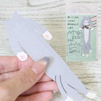 Hand holding the Kutsushita hugging cat bookmark with its packaging