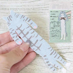 Hand holding the Sabashiro hugging cat bookmark with its packaging