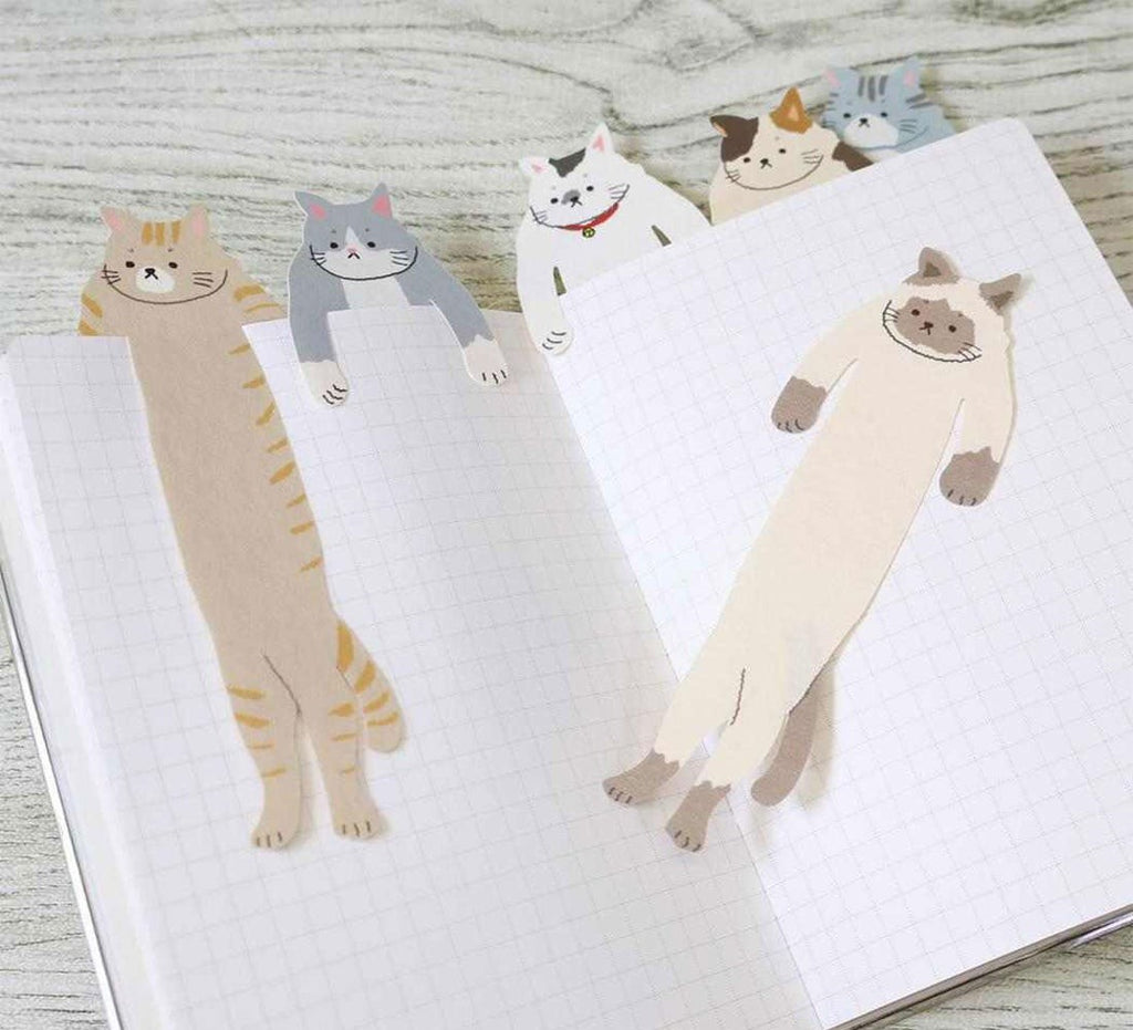 All six ALTA Hugging Cat bookmark designs hanging out of an open notebook