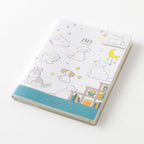 MIDORI Pocket Diary 2027 A6 dog planner open to a weekly spread on a white desk